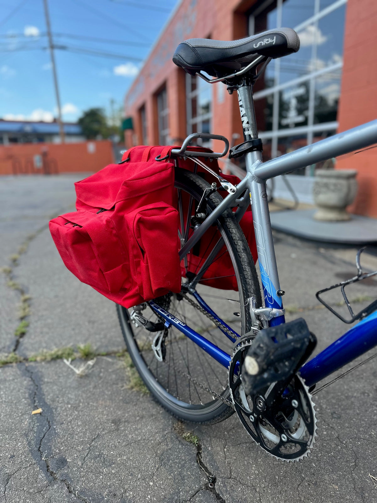 red saddle bag on the back of a bicycle in a parking lot