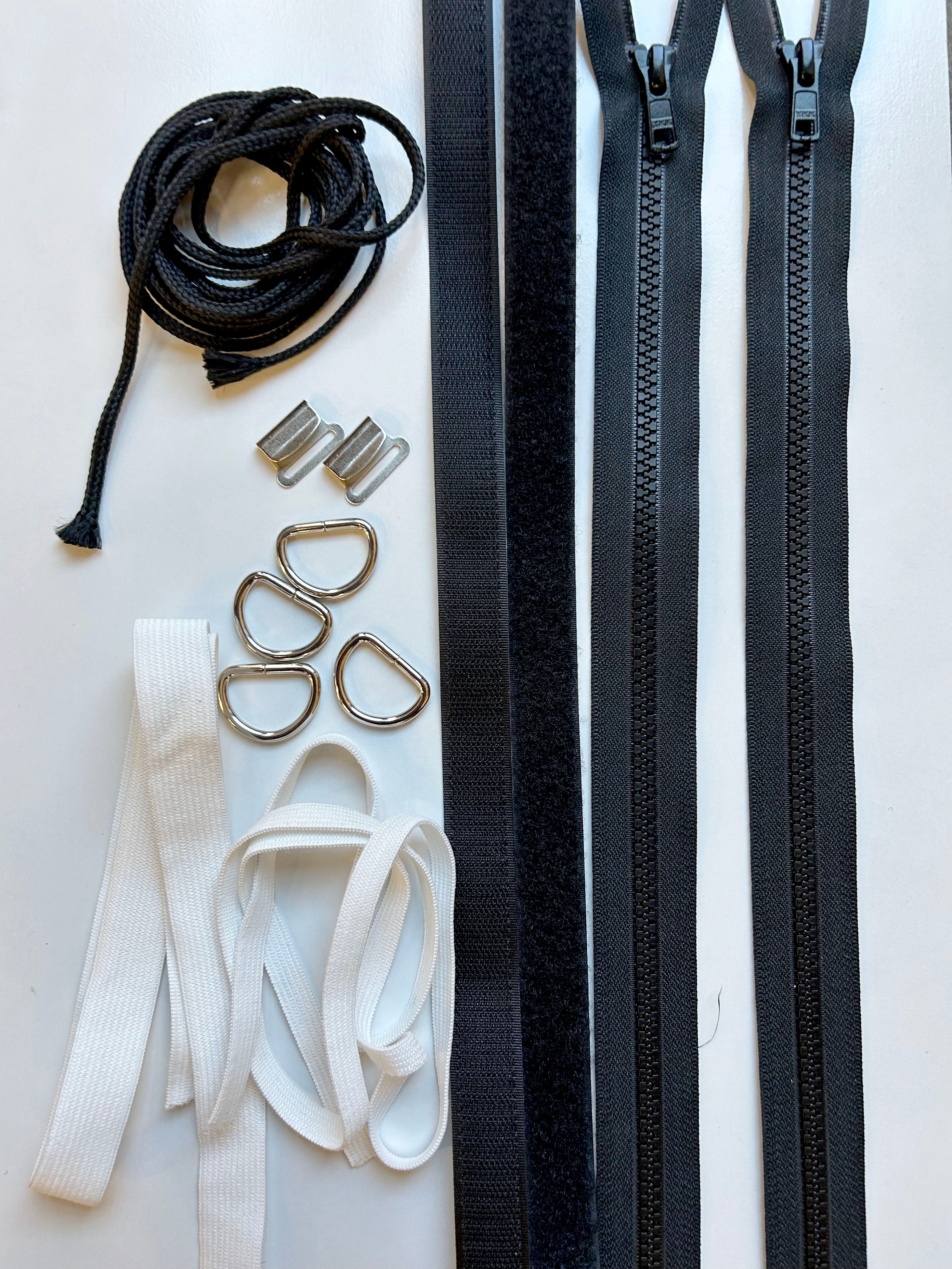 two zippers, velcro, cording, Drings, and white elastic.
