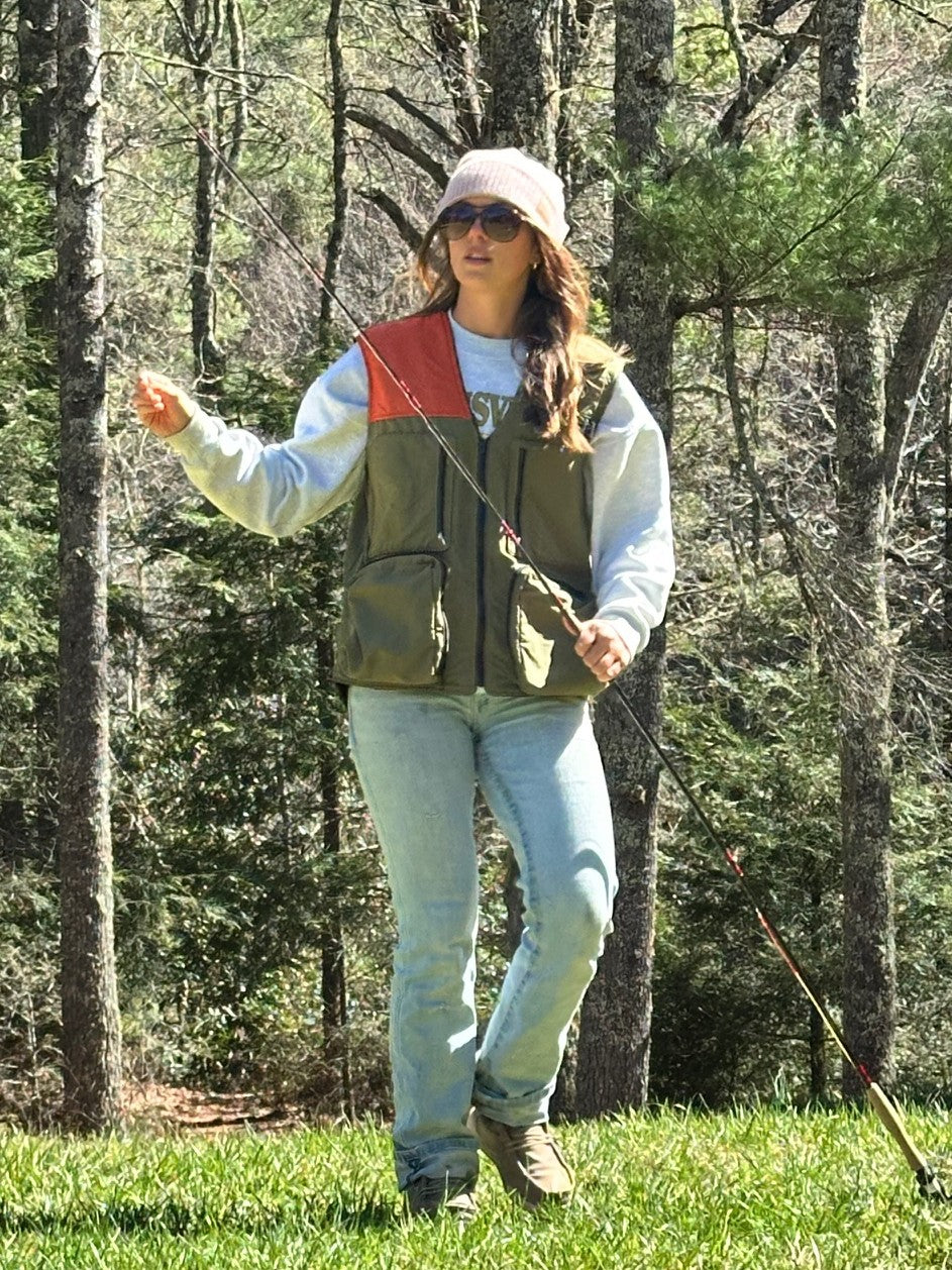 Person fly fishing in a wooded area