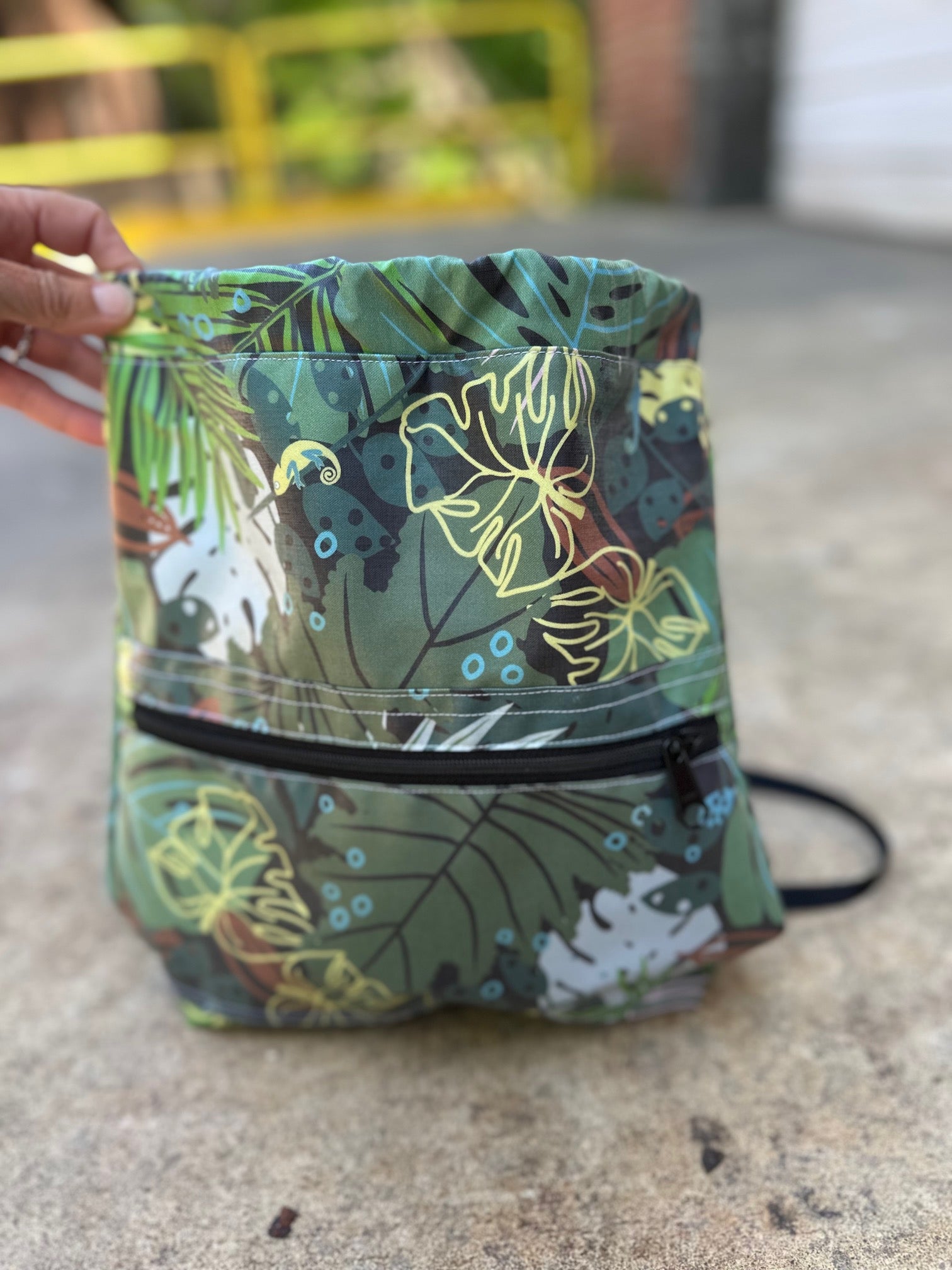 Tropical leaf patterned bag with a zipper on a concrete surface