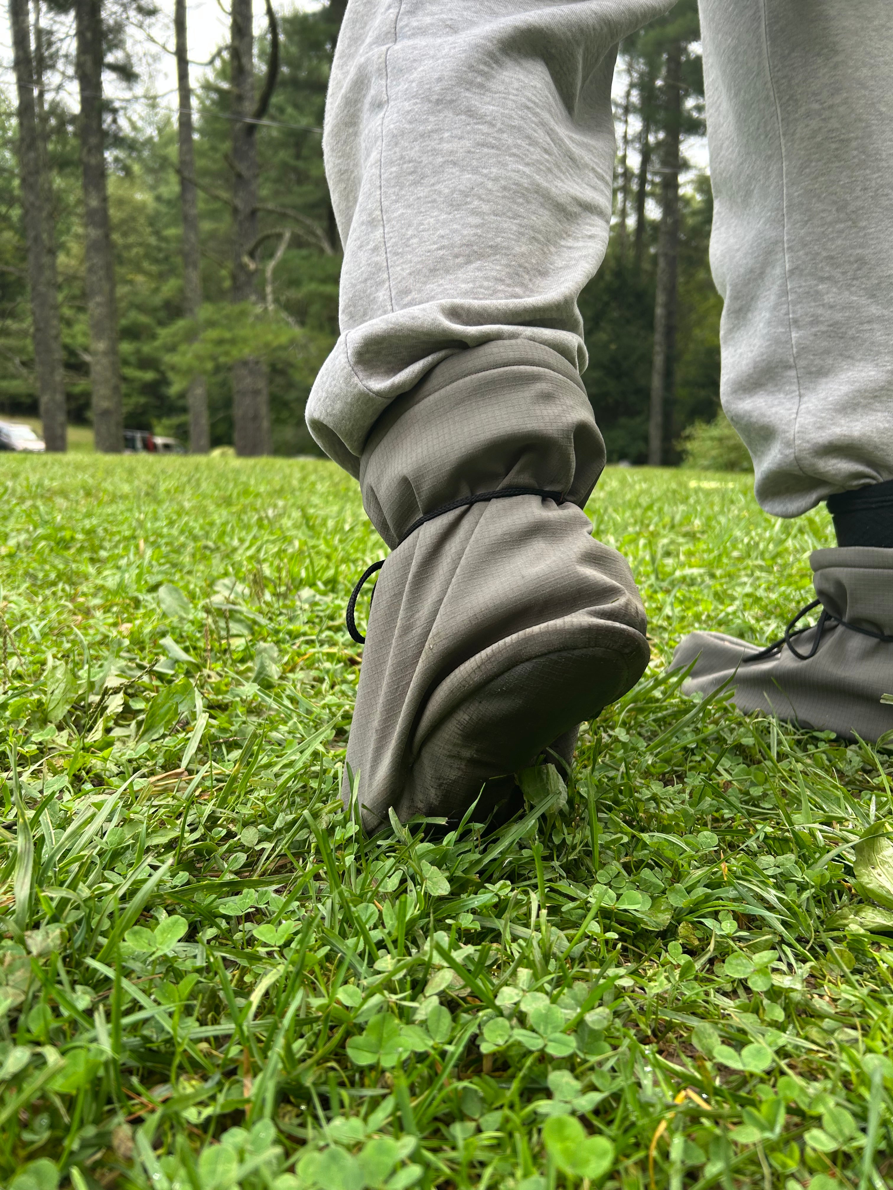 Person wearing a gray pants with high cuffs in a grassy area