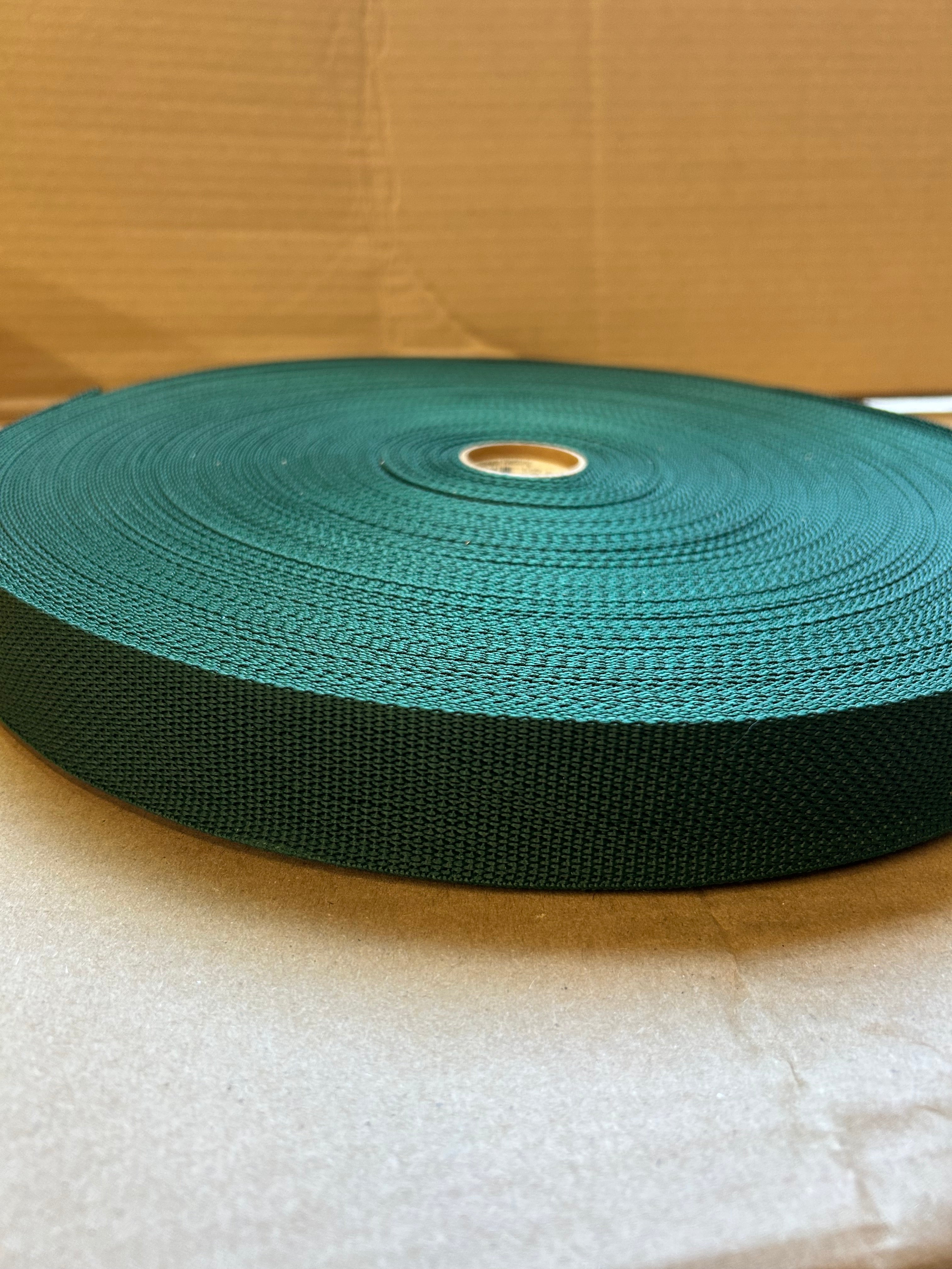 Roll of green webbing on a cardboard surface