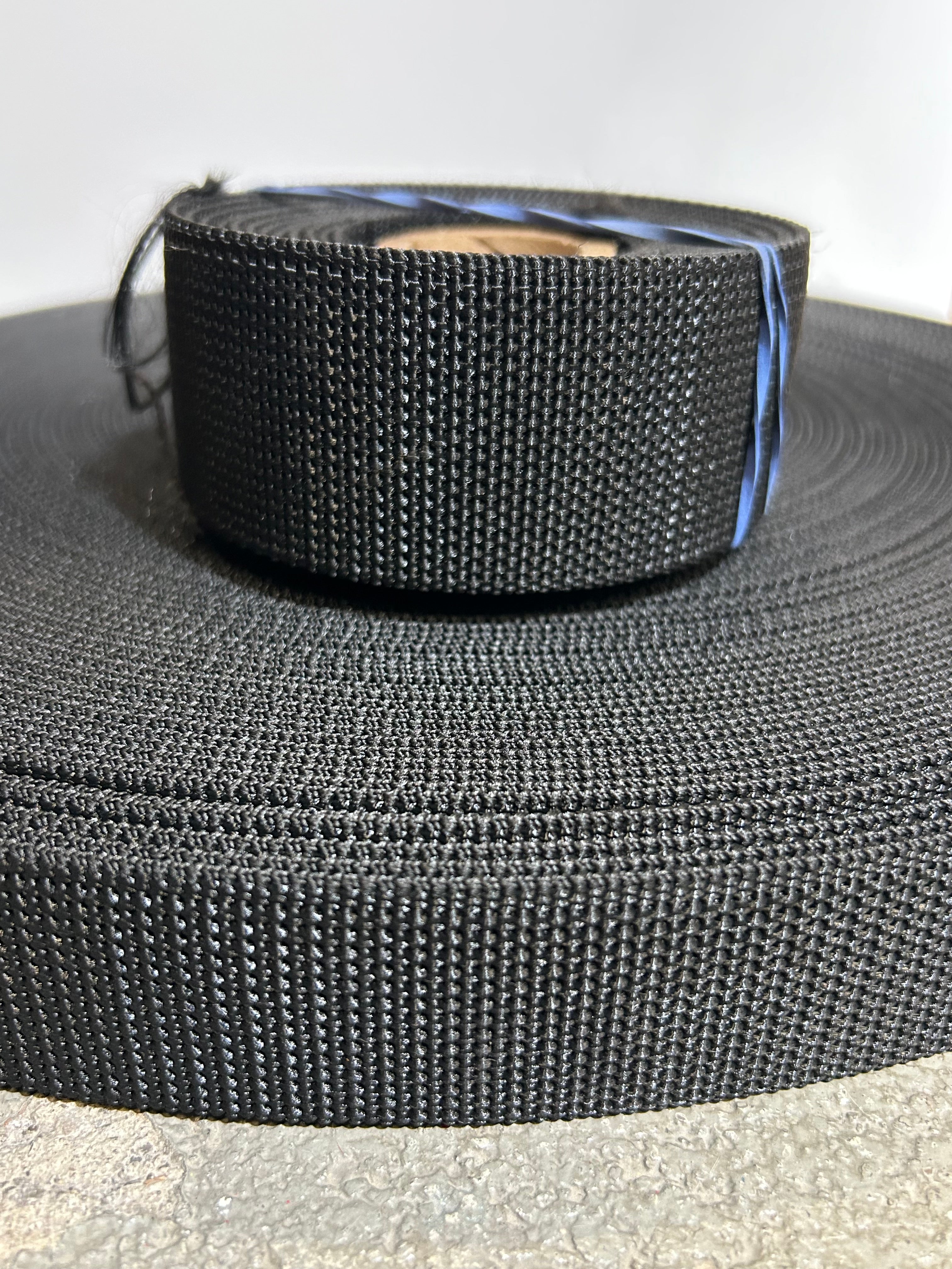 two rolls of black heavy stiff webbing.