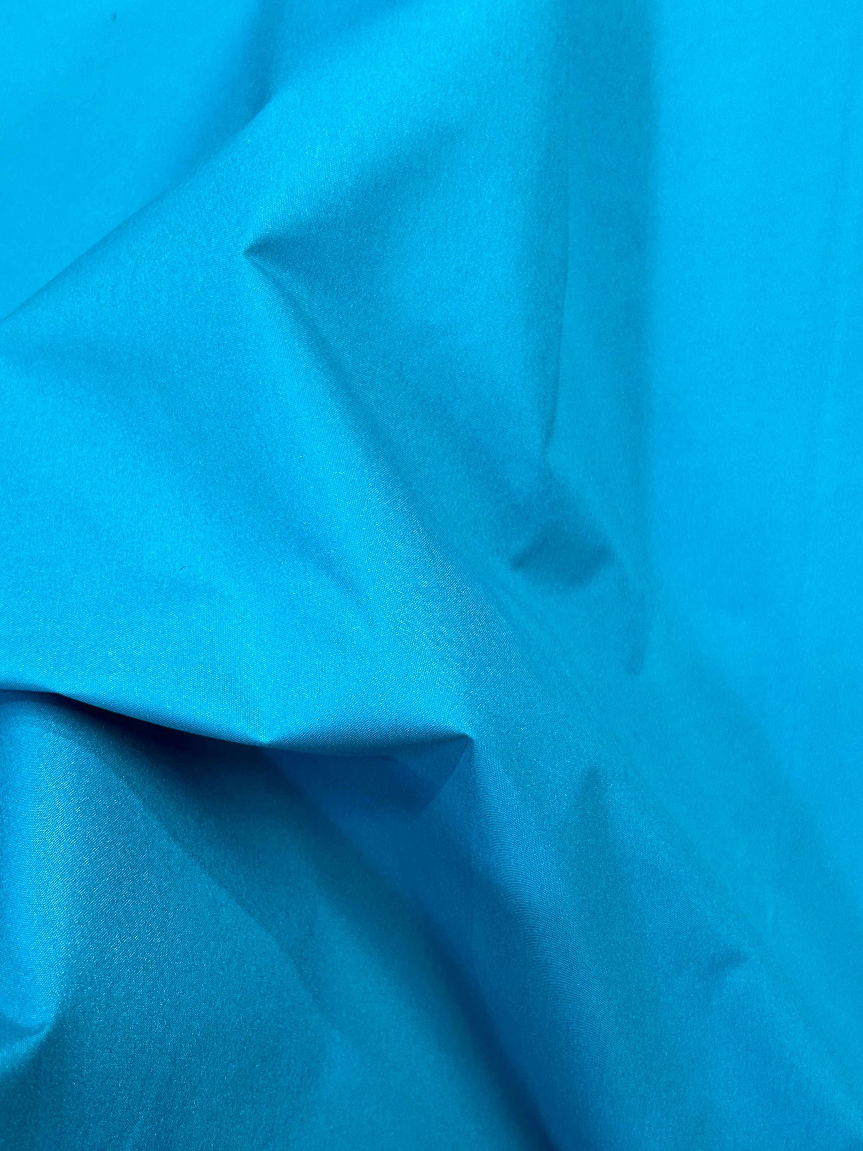 100% Nylon Tactel. Super quality with a DWR finish in a vibrant turquoise color