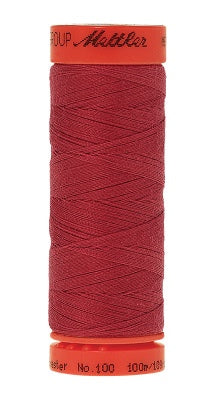 A spool of sewing thread in a deep red color, with orange plastic end caps on a white background.