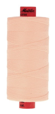 A 1000 m spool of light peach-colored sewing thread with red ends, featuring a red top cap labeled 'Mater 1955' and a red bottom cap.