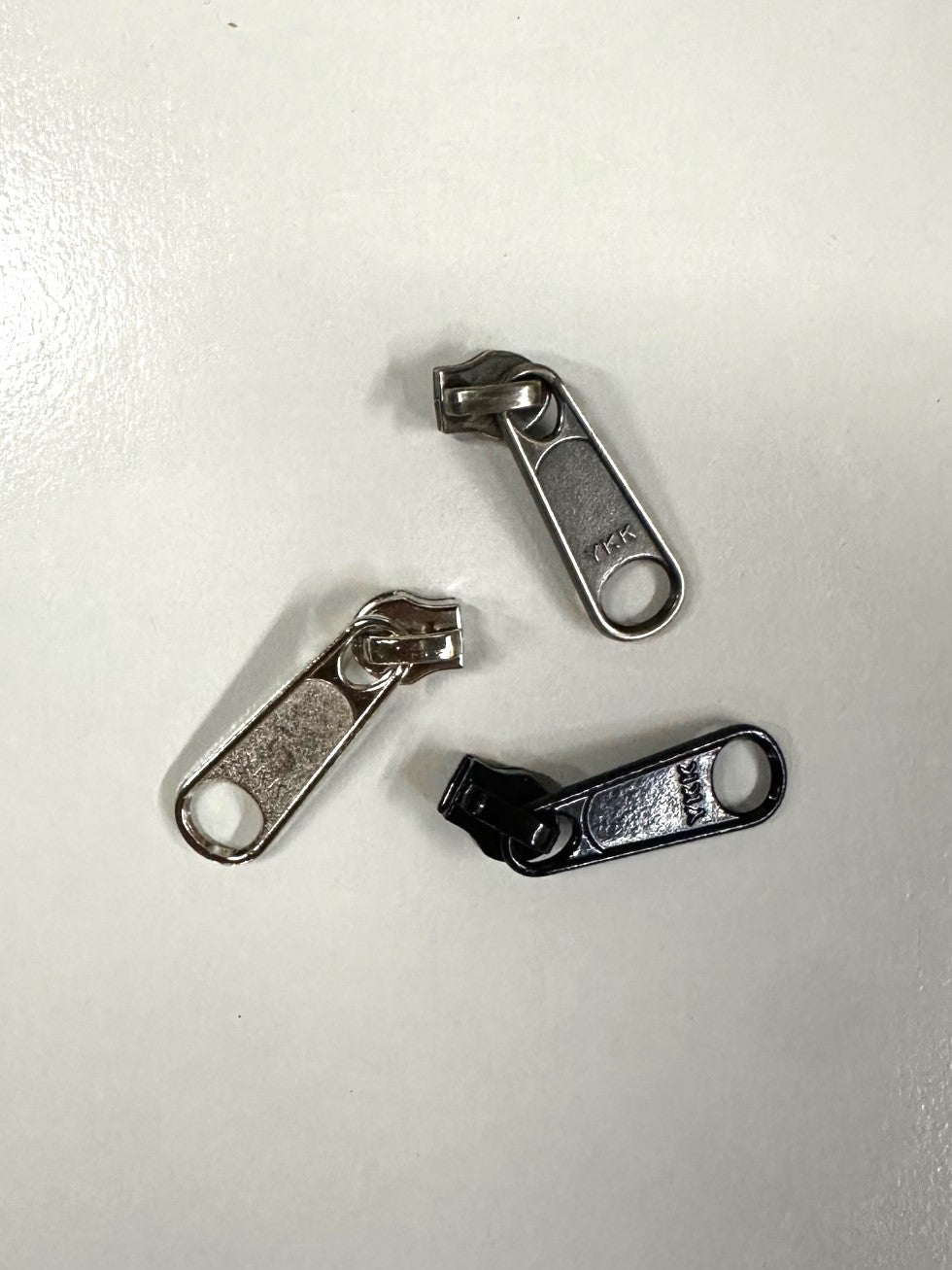 three single non locking coil zipper pulls, 2 silver, 1 black