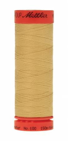 A spool of Mettler sewing thread in a light tan color, featuring red plastic end caps with black printed branding and text.