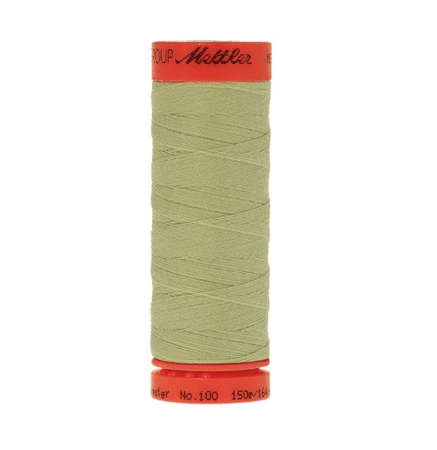A spool of Mettler sewing thread in a light olive green color, wound on a red plastic spool with black printed text.
