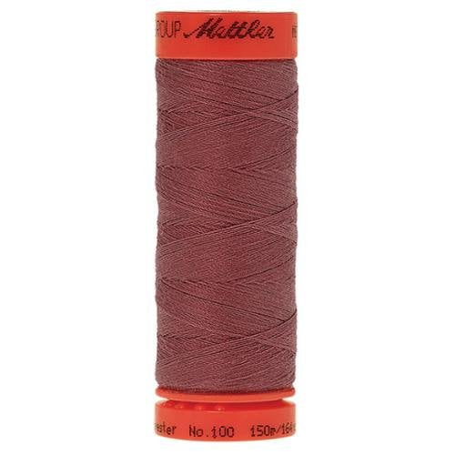 A single spool of Mettler sewing thread in a dusty rose or mauve-brown shade, with bright orange-red plastic end caps on a plain white background.