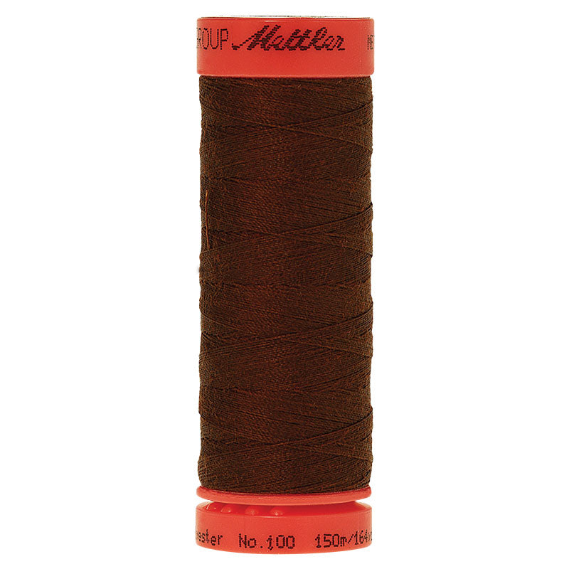 A spool of dark brown sewing thread with a bright red-orange plastic core, featuring the Mattler brand name on the top cap.