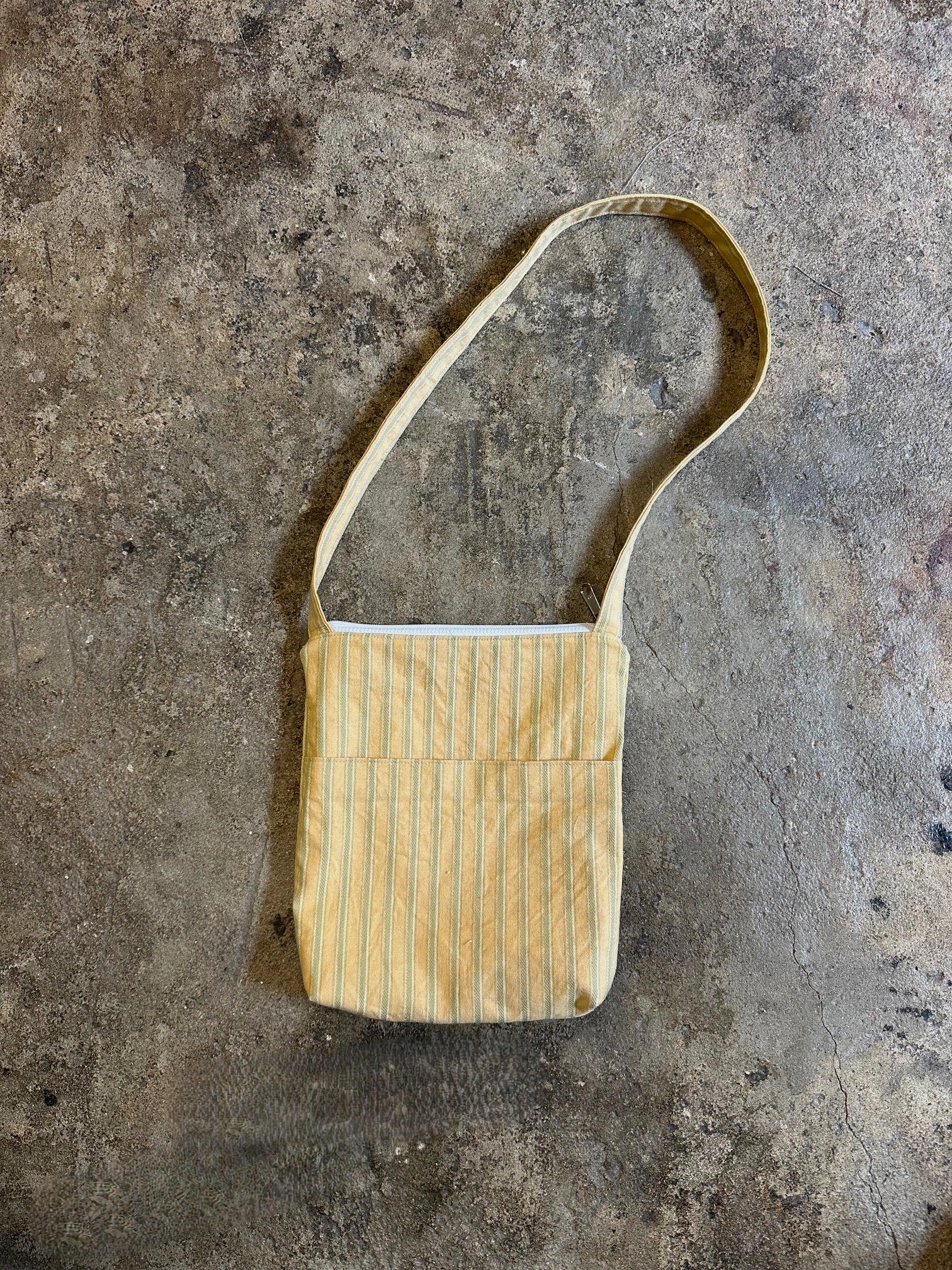 Small striped bag on a textured gray surface