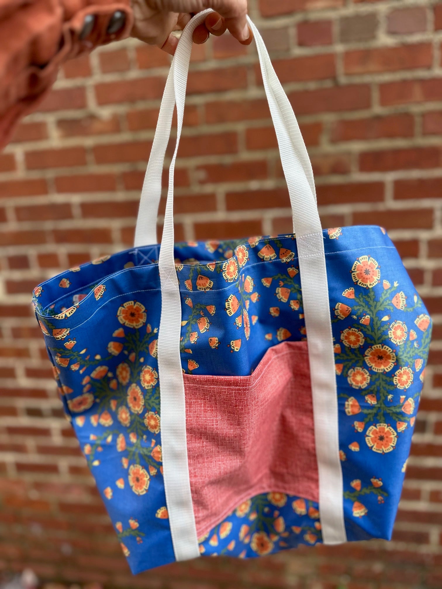 blue floral tote with red pocket and white straps