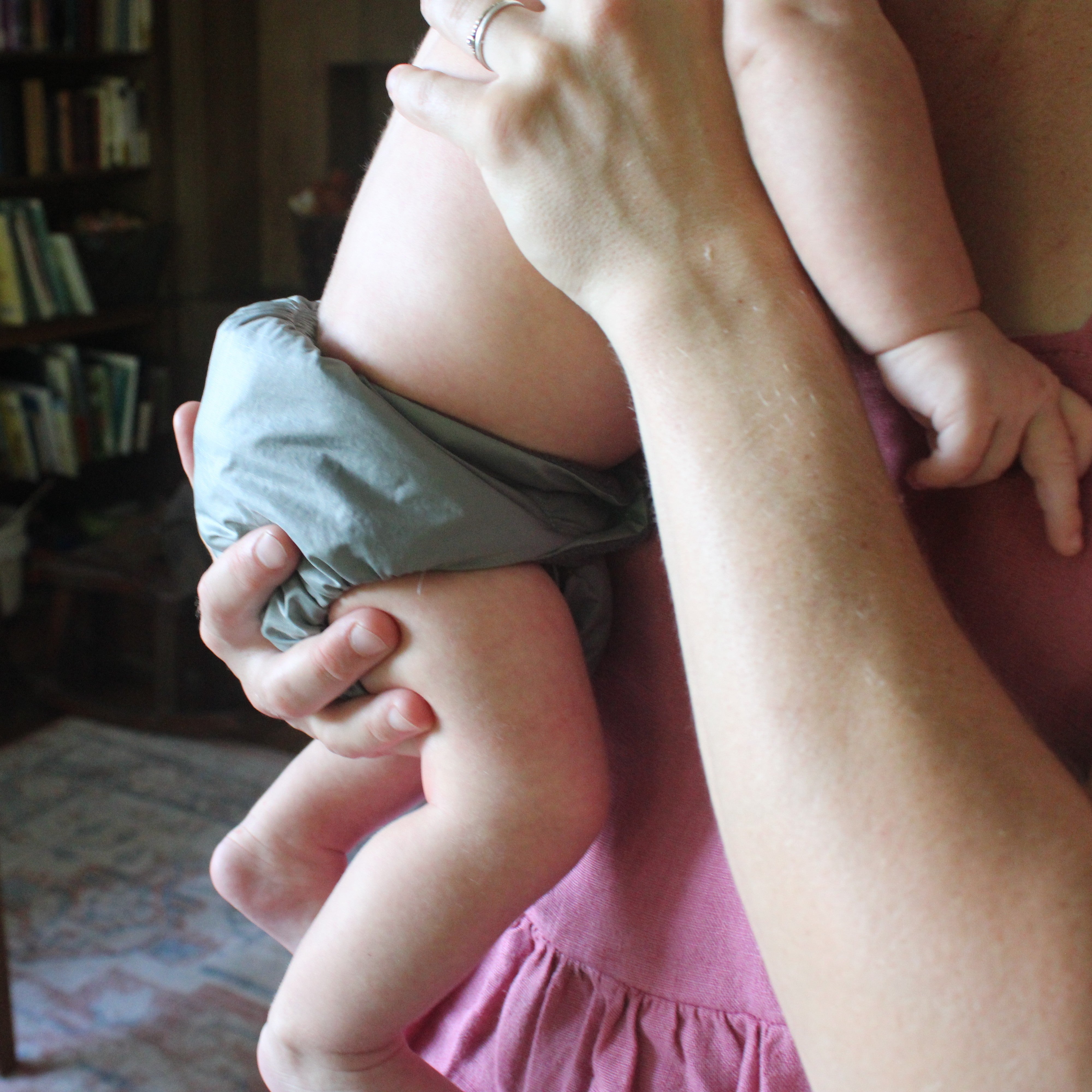 close up of baby in a cloth diaper in moms arms