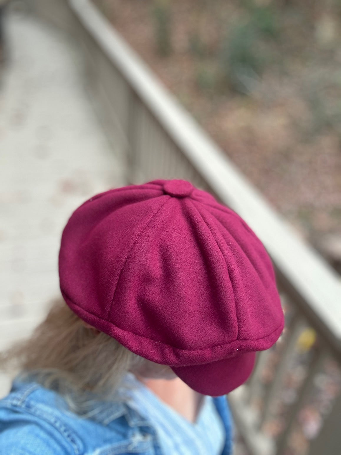 Person wearing a maroon cap with a blurred background - view of top of cap