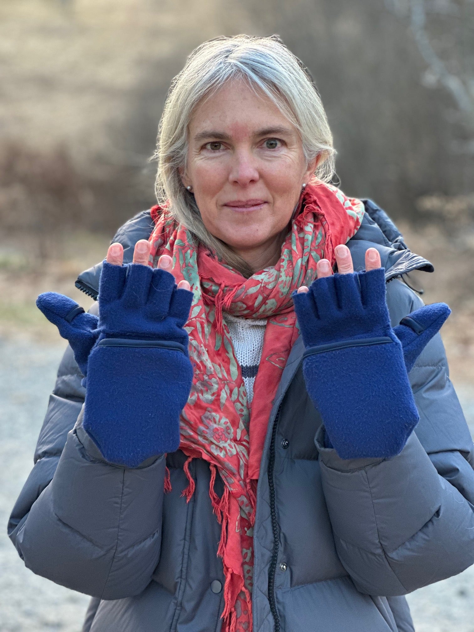Person wearing blue fingerless gloves outdoors