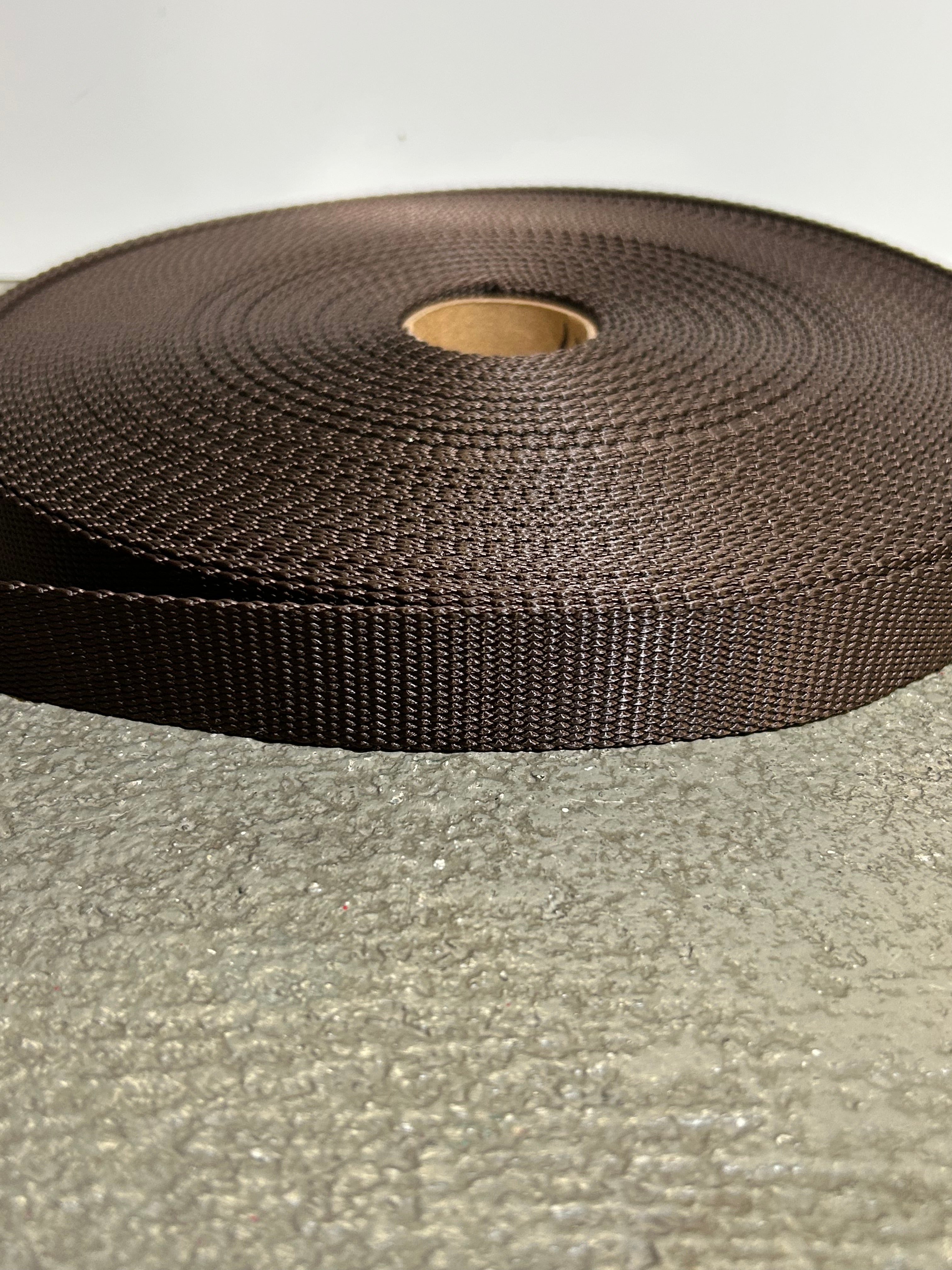 Roll of brown webbing on a textured gray background