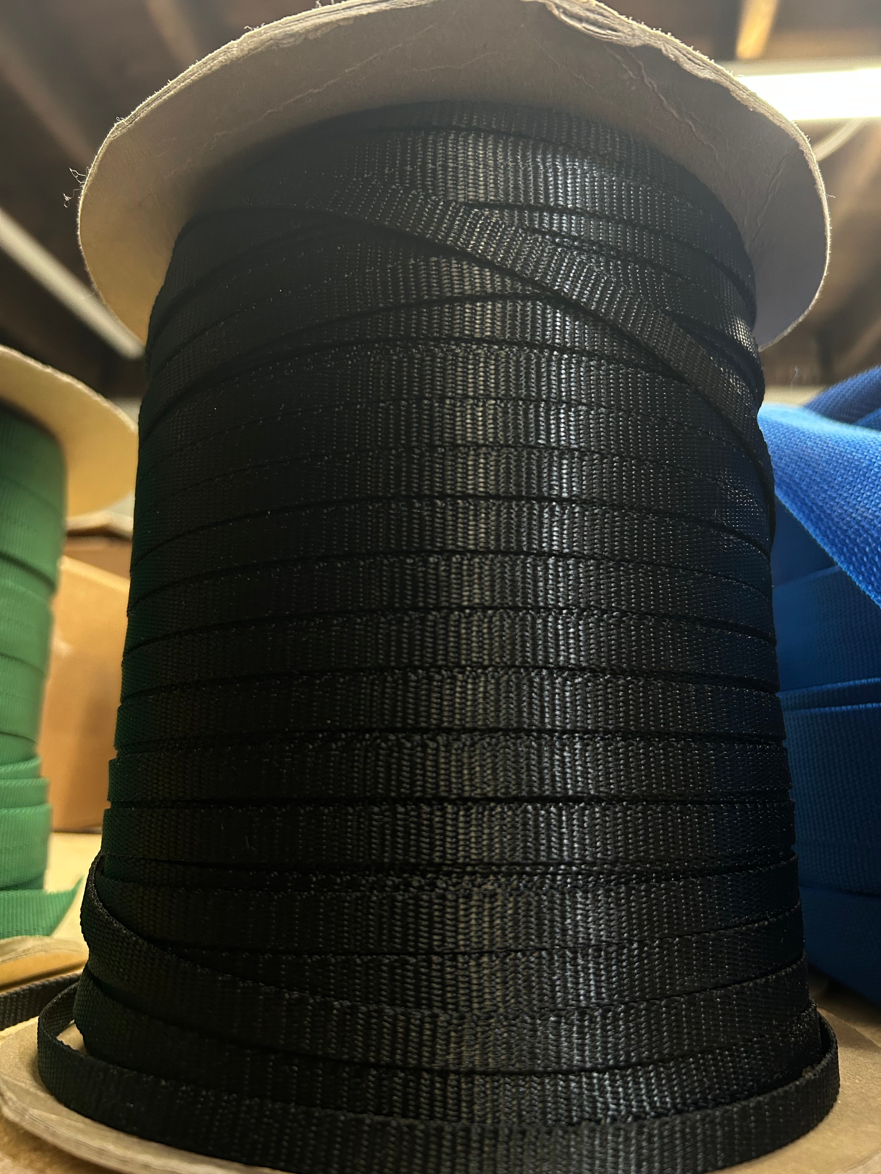 Spool of black tape on a cardboard tube with a blurred background