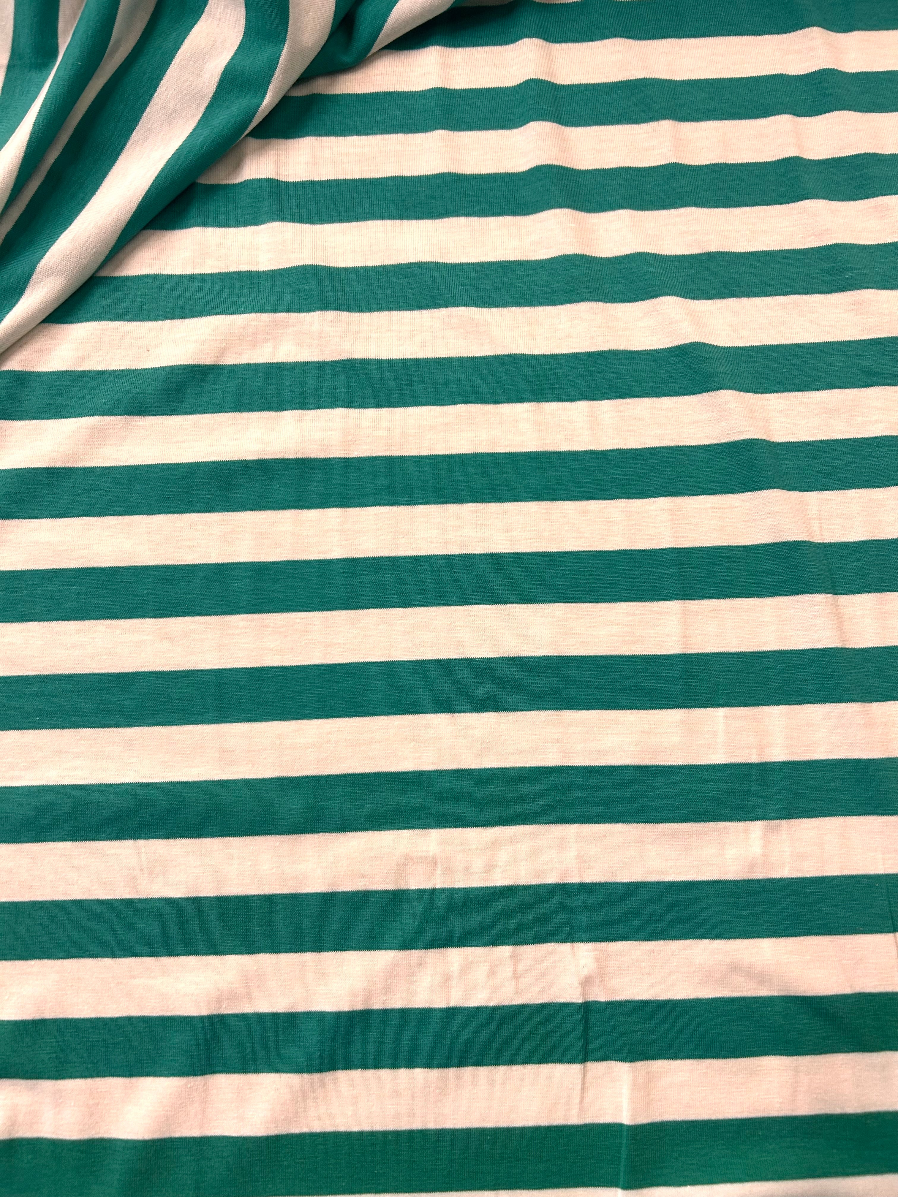 Teal and white horizontal striped fabric with a draped fold in the top left corner.