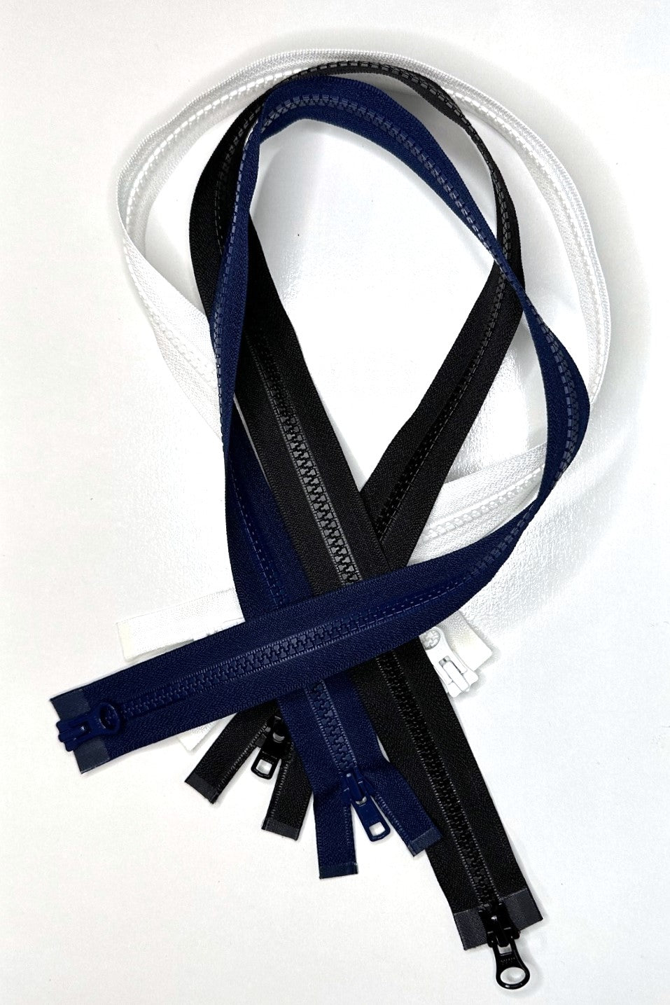 three two way separating zippers in a pile