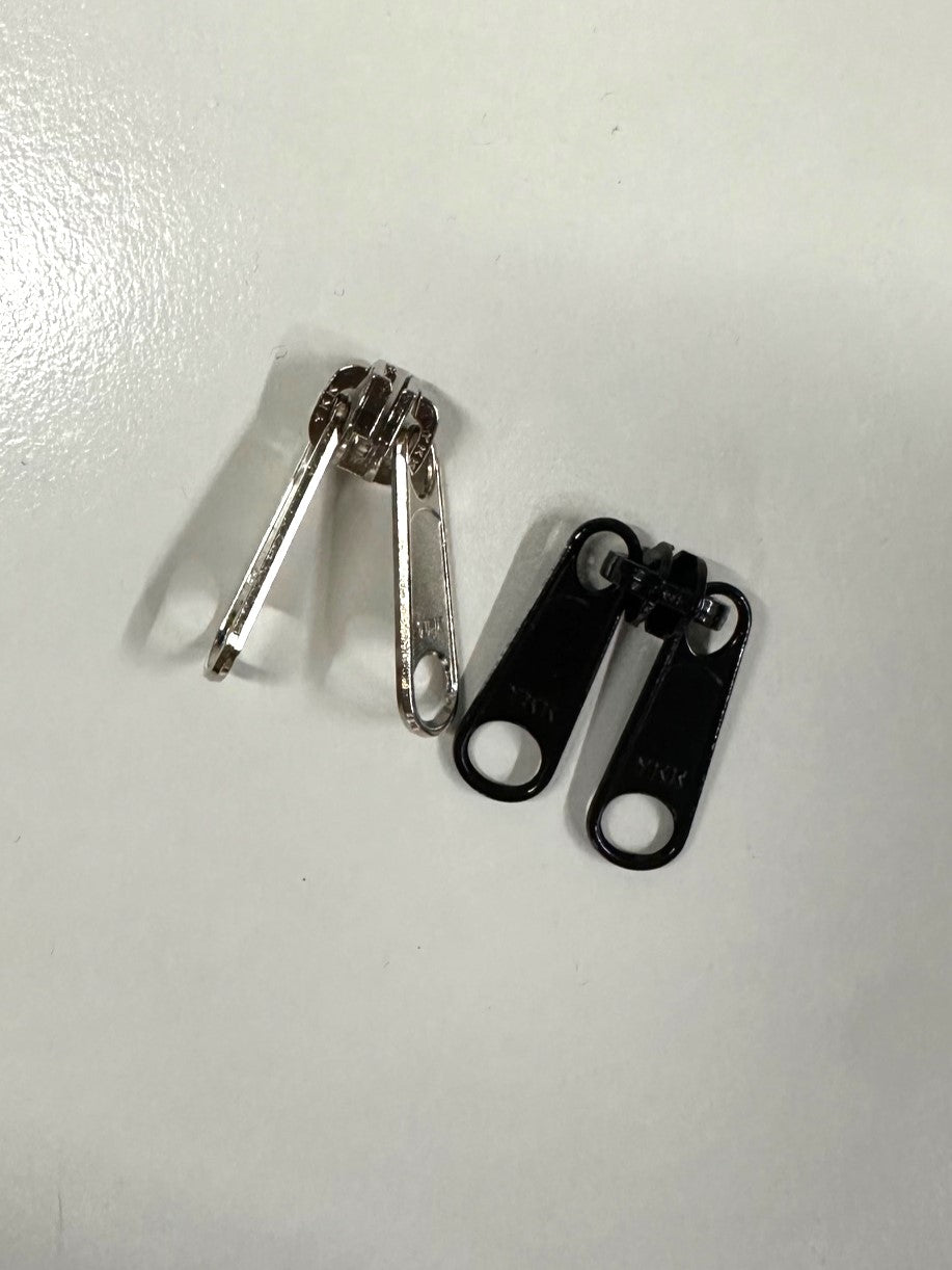 two reversible zipper pulls, one black, one silver