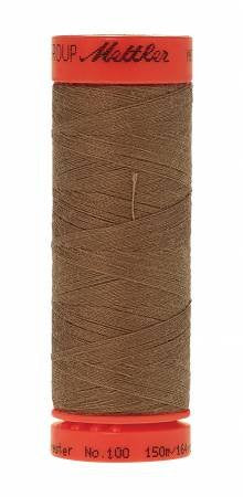 Spool of brown thread with a red label on a white background