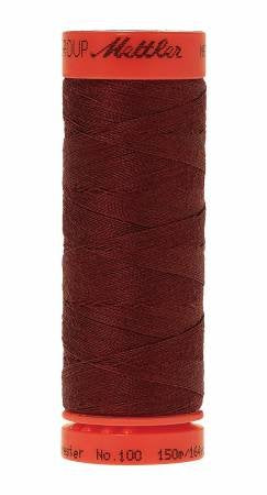 A spool of Mettler sewing thread in a deep burgundy red color, with a bright orange-red top and bottom band showing the brand name.