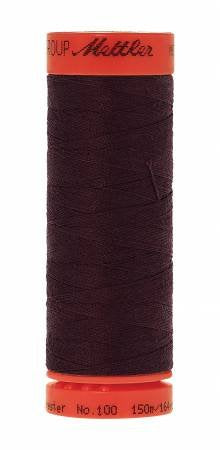 A spool of Mettler sewing thread in a very dark plum or aubergine color, with a bright orange-red plastic spool showing the Mettler brand name on the top and bottom.