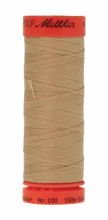 A spool of Mettler sewing thread in a light tan color, featuring red plastic end caps with black printed branding and text.