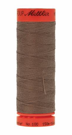 A spool of Mettler sewing thread in a medium brown color, featuring a bright orange-red top and bottom cap with black branding text, isolated on a white background.