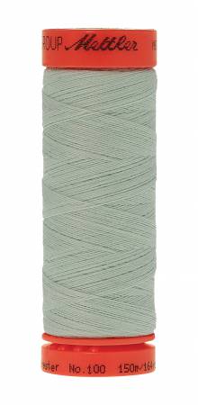 A spool of Mettler sewing thread in a pale sage green color, wound on a red plastic spool with the brand name 'Mettler' visible on the top cap.