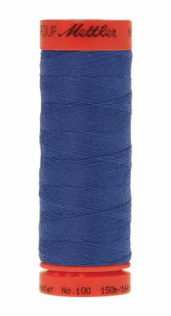 A spool of Mettler sewing thread in a deep blue color, wound on a red plastic spool with the Mettler brand name visible on the top and bottom rims.