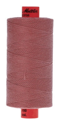 A single 1000m spool of thread in a dusty rose or mauve color, with red end caps. The top cap has a black logo that reads 'Mettler' and the bottom cap reads '100 col.