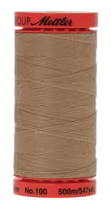 A spool of thread wound on a red spool, with the brand name 'Mettler' visible on the top red rim and 'No. 100 500m/54yd' on the bottom red rim, photographed against a plain white background.