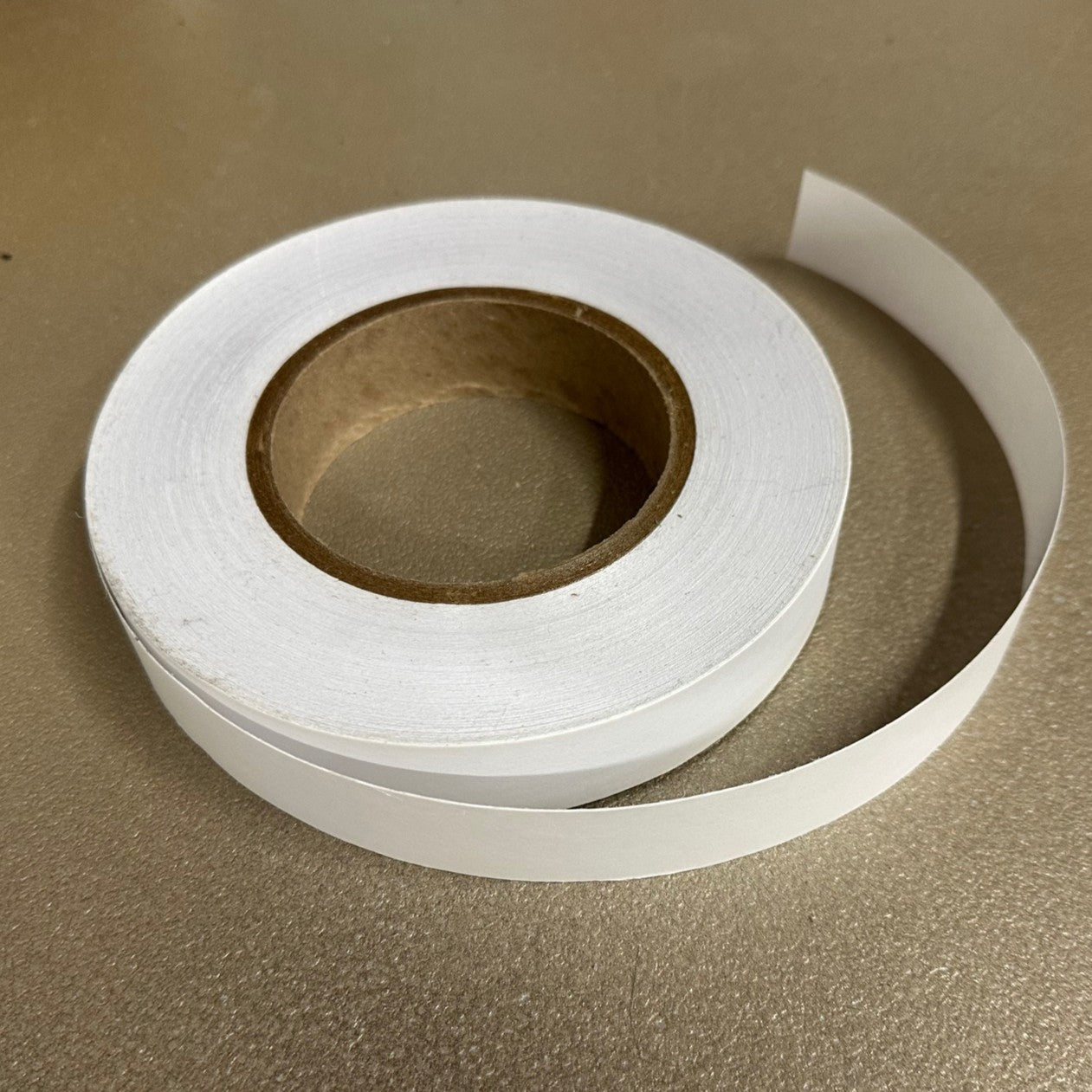 Roll of white tape on a brown surface