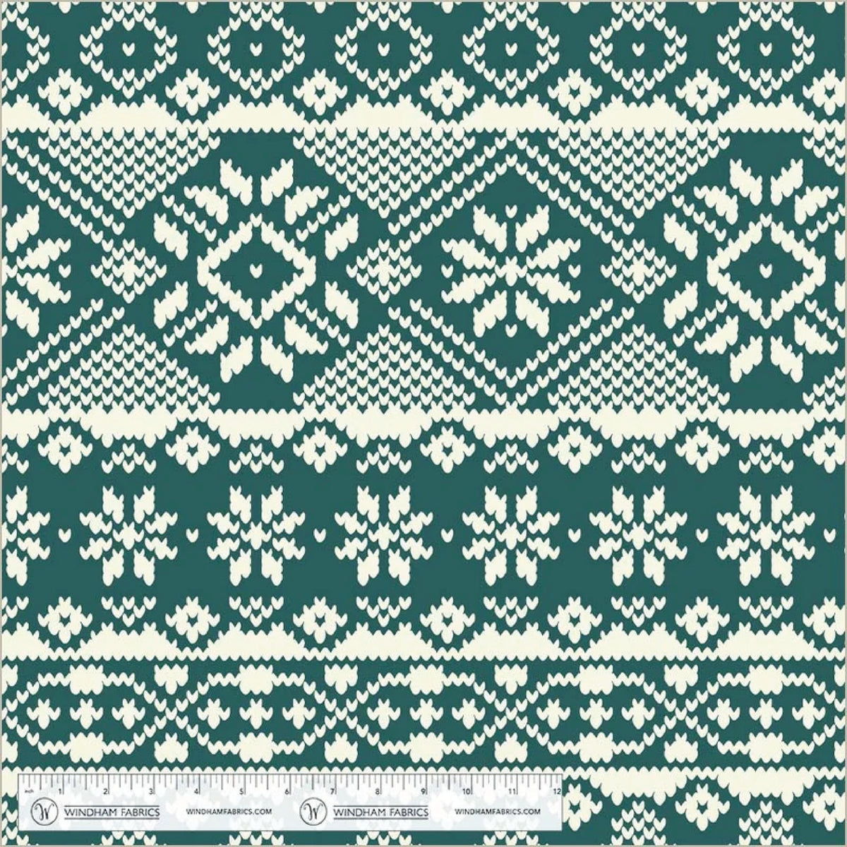 Fleece in a  print of white snowflakes on a spruce green background. With a white ruler on the bottom for scale.