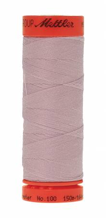 A spool of sewing thread wound on a bright orange spool, with the brand name 'Mettler' visible on the top and bottom orange caps. The thread itself is a muted, dusty mauve-pink color.